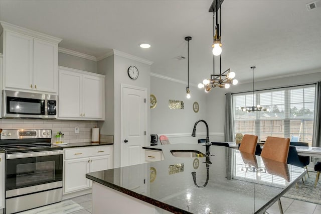 kitchen featuring hanging light fixtures, white cabinetry, appliances with stainless steel finishes, and sink