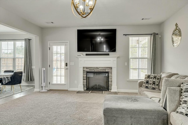 living room with light colored carpet, a fireplace, and a chandelier