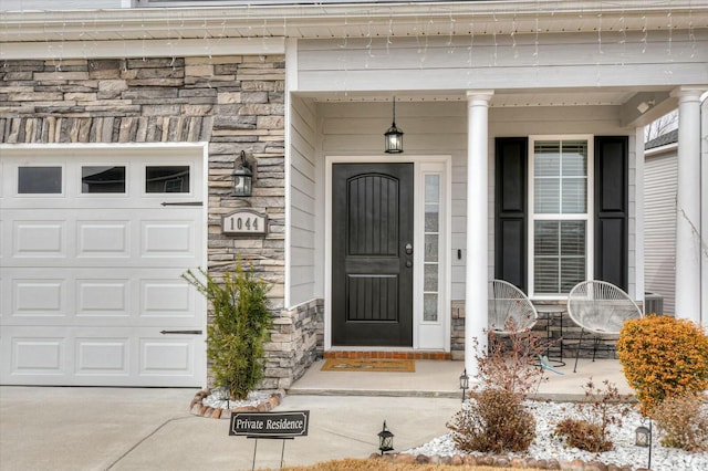 doorway to property with a garage and a porch