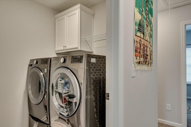 washroom with cabinets and washing machine and dryer