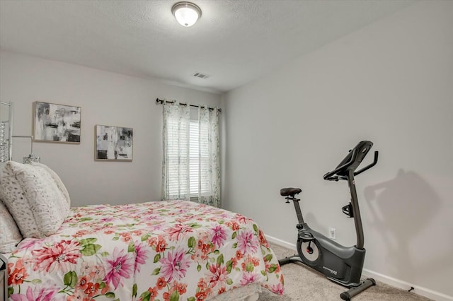 bedroom with a textured ceiling and carpet