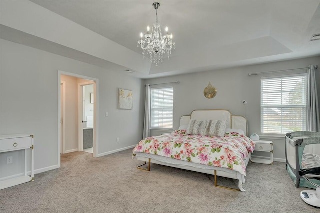 bedroom featuring light colored carpet, a chandelier, and a tray ceiling