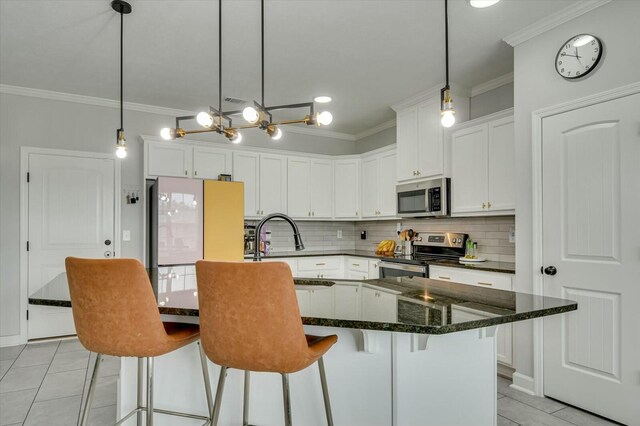 kitchen featuring white cabinetry, a center island with sink, and appliances with stainless steel finishes