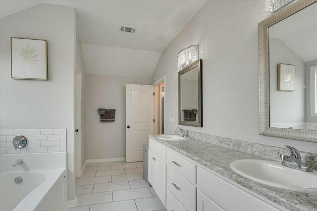 bathroom featuring lofted ceiling, vanity, and a tub