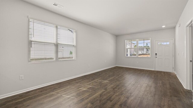 interior space featuring visible vents, baseboards, and dark wood finished floors