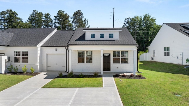 view of front facade with an attached garage, brick siding, a front lawn, driveway, and a shingled roof