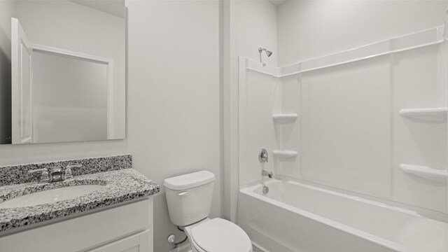 bathroom with tub / shower combination, toilet, and vanity
