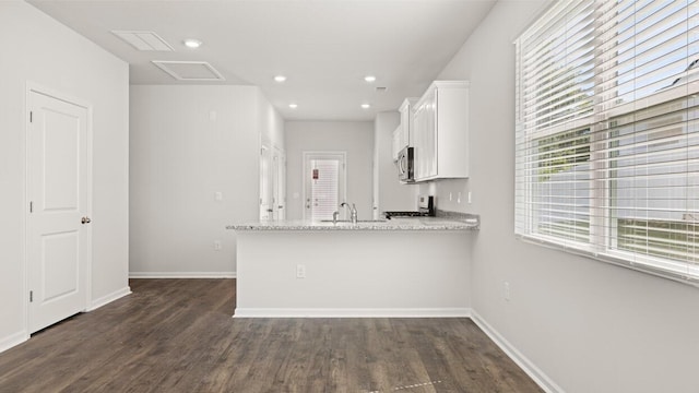 kitchen with white cabinetry, dark wood-type flooring, a peninsula, baseboards, and recessed lighting