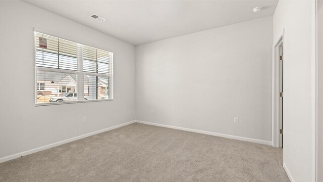 carpeted empty room with baseboards and visible vents