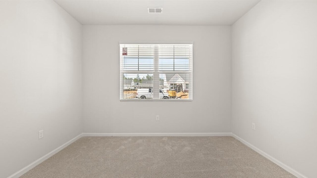 carpeted spare room with baseboards and visible vents