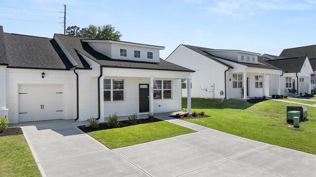 view of front of property with driveway, brick siding, a garage, and a front lawn