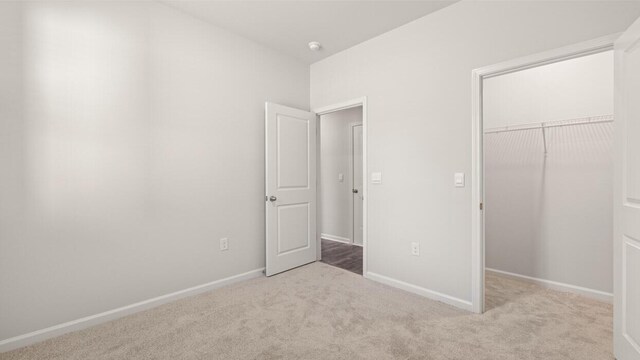 unfurnished bedroom featuring baseboards, a closet, and carpet flooring