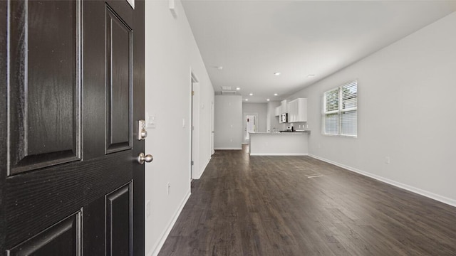 unfurnished living room featuring baseboards, recessed lighting, and dark wood-type flooring