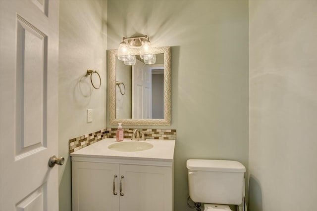 bathroom featuring vanity, toilet, and decorative backsplash