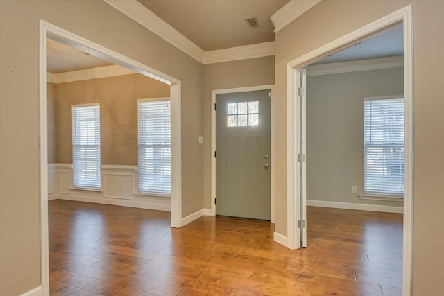 entrance foyer with ornamental molding and light hardwood / wood-style flooring