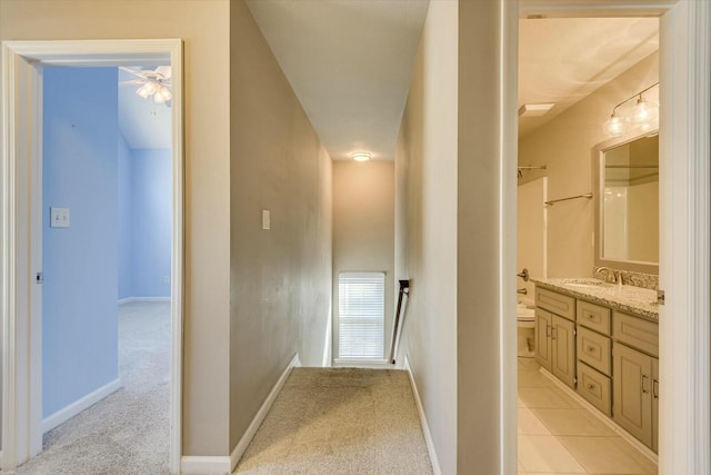 corridor featuring sink and light colored carpet