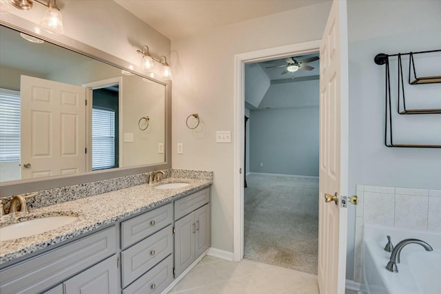 bathroom with ceiling fan, vanity, tile patterned flooring, and a washtub