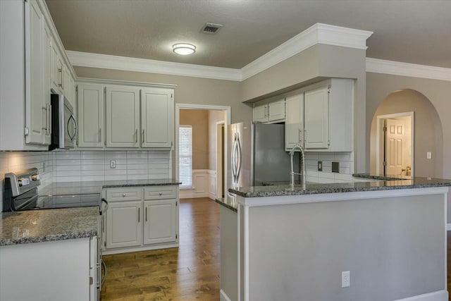 kitchen featuring white cabinetry, appliances with stainless steel finishes, crown molding, and kitchen peninsula