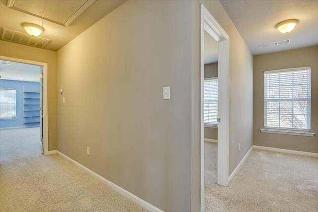 hallway featuring light colored carpet