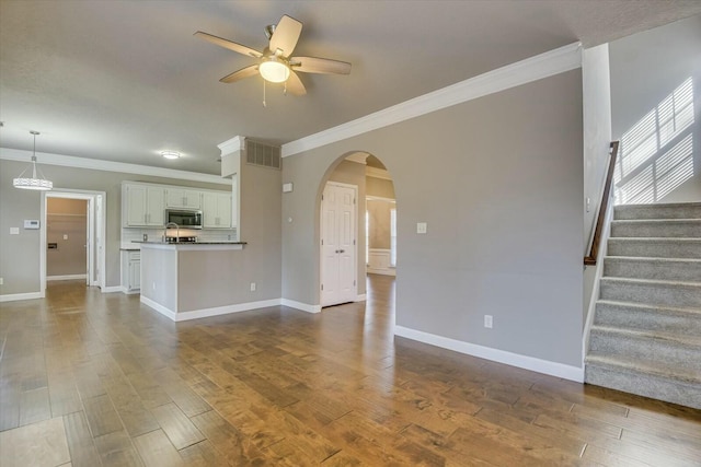 unfurnished living room with hardwood / wood-style flooring, ceiling fan, and crown molding