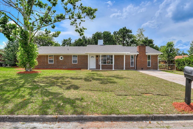 ranch-style house with a front yard, brick siding, and a chimney