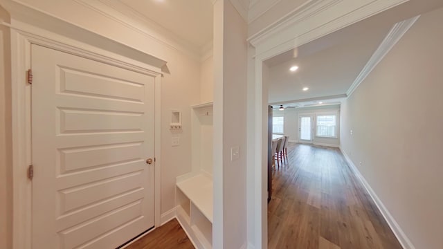 corridor with baseboards, wood finished floors, attic access, and crown molding