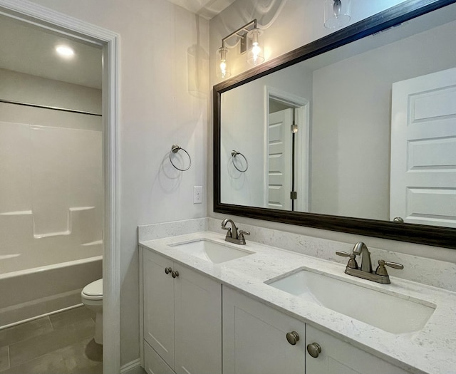 full bathroom featuring a sink, bathing tub / shower combination, toilet, and double vanity