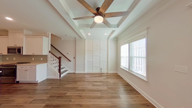 interior space featuring beam ceiling, light wood-style flooring, baseboards, and stairs