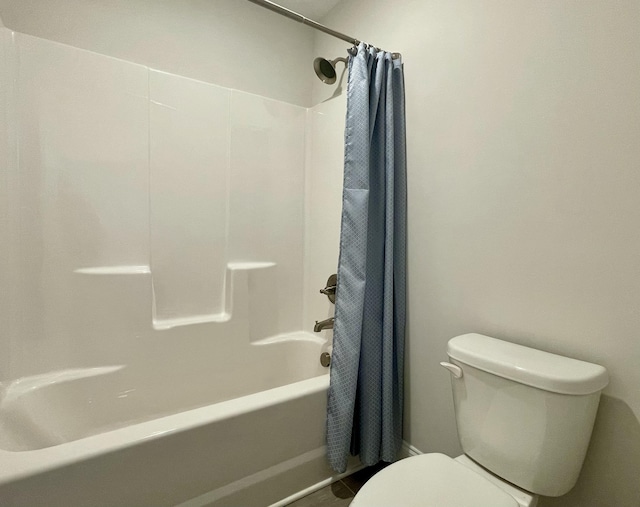 bathroom with shower / bath combo with shower curtain and toilet