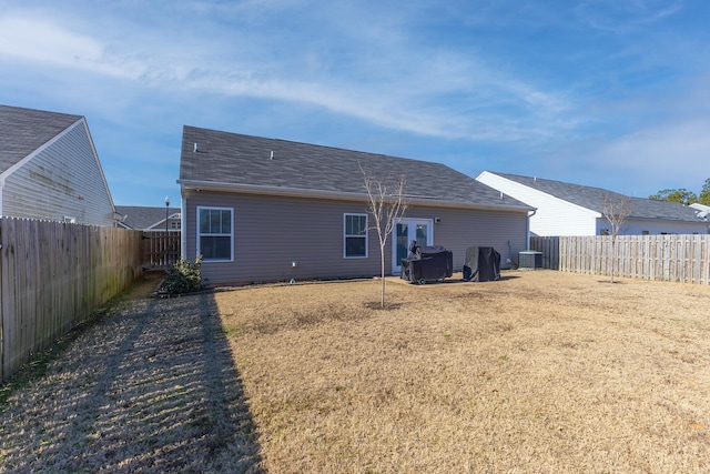 back of house featuring central air condition unit, french doors, and a yard