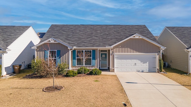 view of front of property featuring central air condition unit, covered porch, and a garage