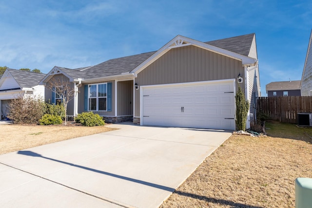 ranch-style home with central air condition unit and a garage