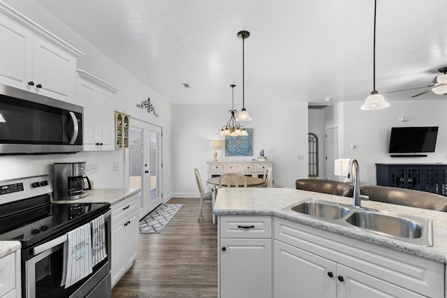 kitchen with pendant lighting, sink, white cabinetry, appliances with stainless steel finishes, and french doors