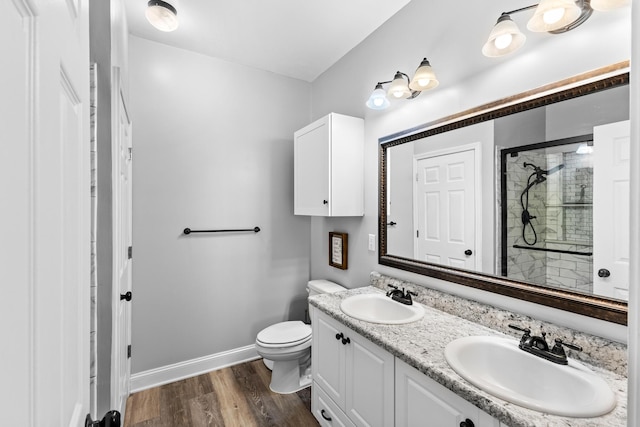 bathroom featuring a shower with shower door, vanity, toilet, and hardwood / wood-style flooring