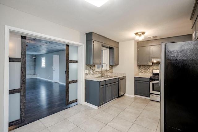 2705 S Vernon Dr, Augusta, GA 30906 - kitchen with stainless steel appliances, backsplash, under cabinet range hood, light tile patterned floors, and gray cabinets