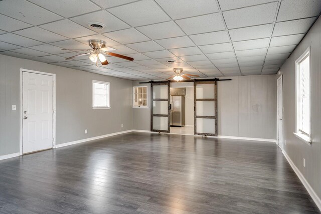 2705 S Vernon Dr, Augusta, GA 30906 - unfurnished living room with a barn door, ceiling fan, dark wood-type flooring, and a paneled ceiling