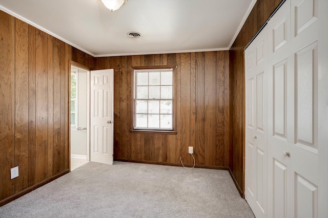 2705 S Vernon Dr, Augusta, GA 30906 - unfurnished bedroom featuring wooden walls, carpet, crown molding, and a closet