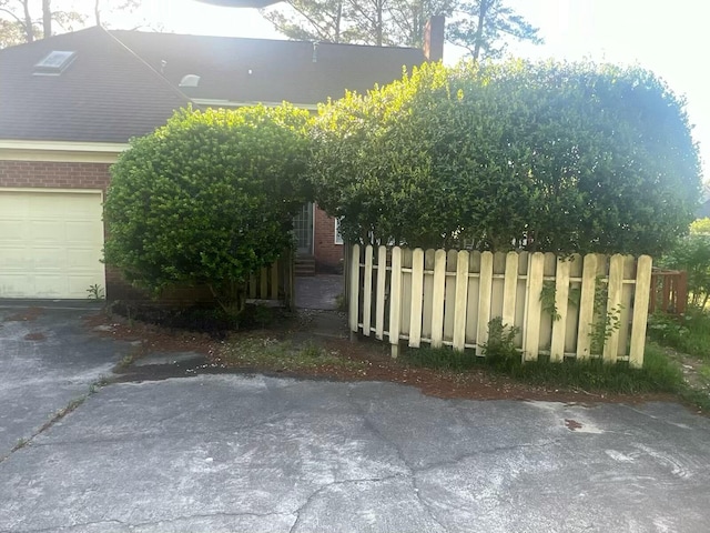 view of side of home featuring a garage and fence