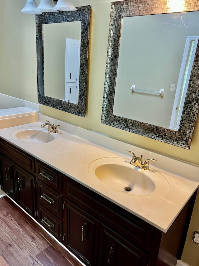 bathroom featuring double vanity and wood finished floors