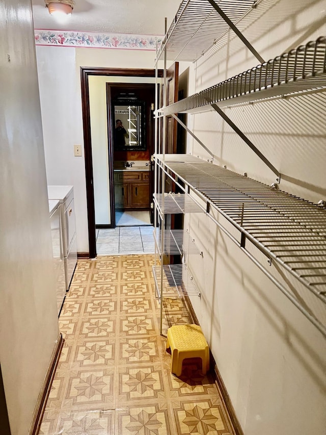 clothes washing area featuring washing machine and clothes dryer and baseboards