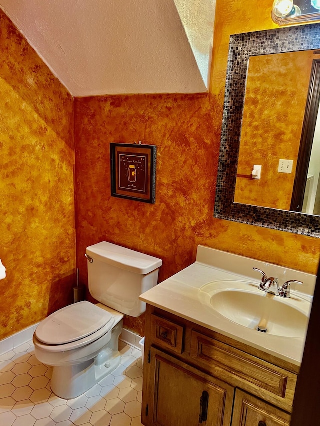 bathroom featuring tile patterned floors, toilet, vanity, and a textured ceiling