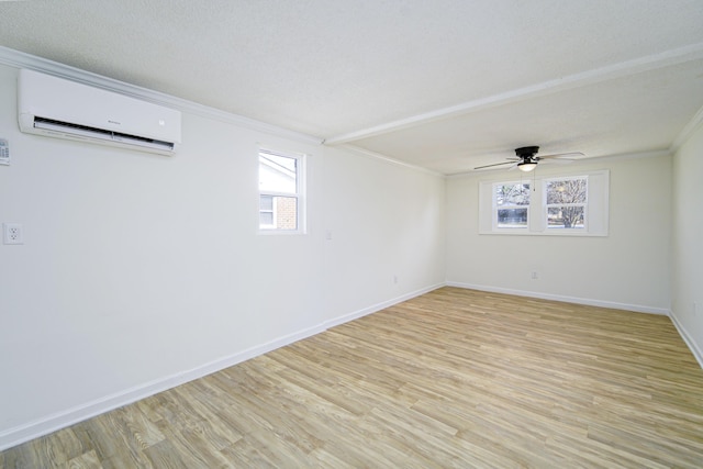 unfurnished room with plenty of natural light, ornamental molding, a wall unit AC, and light wood-type flooring