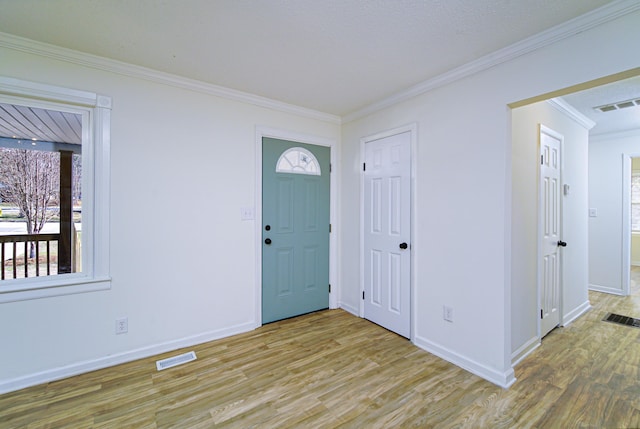 foyer entrance with light hardwood / wood-style flooring and crown molding