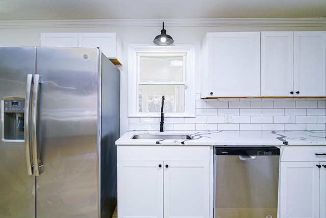 kitchen with white cabinetry, stainless steel appliances, tasteful backsplash, sink, and light stone counters