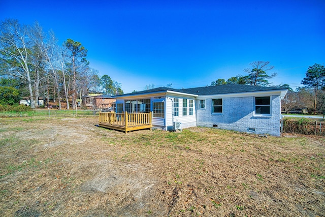 rear view of property featuring a deck and a yard