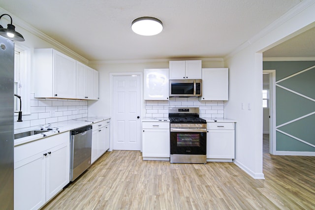 kitchen featuring stainless steel appliances, white cabinets, and tasteful backsplash