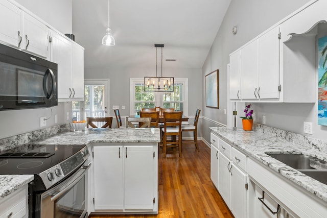 kitchen featuring decorative light fixtures, white cabinetry, stainless steel electric range oven, and lofted ceiling