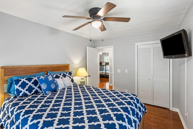 bedroom featuring ceiling fan, dark wood-type flooring, and a closet