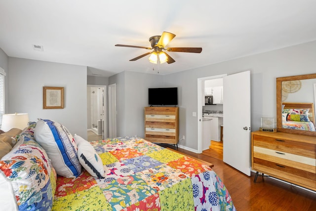 bedroom featuring light wood-type flooring, ensuite bathroom, and ceiling fan