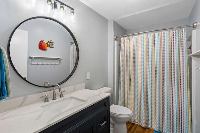 bathroom featuring a shower with curtain, vanity, hardwood / wood-style flooring, and toilet